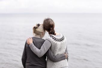 Due generazioni di donne che si abbracciano, guardando il mare