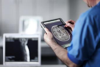 Medico in possesso di computer portatile con scansione MR