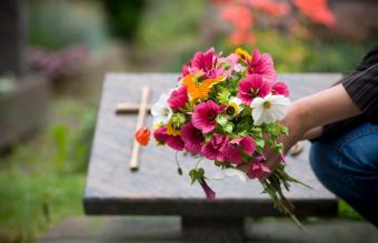 Donna che lascia fiori alla tomba