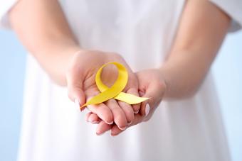 Donna che tiene il nastro giallo per la consapevolezza del suicidio