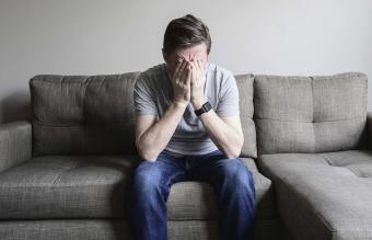 Uomo maturo depresso seduto sul divano