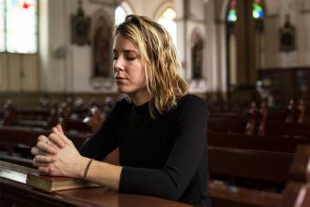 madre inginocchiata pregare in chiesa