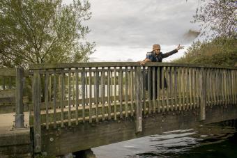 donna che sparge le ceneri cremate dal ponte nell'acqua