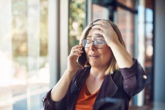 Donna che sembra sconvolta mentre parla su un telefono cellulare