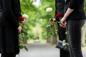 Mostra una famiglia di quattro persone con fiori in onore di una persona cara