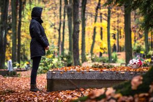 Persona in piedi davanti a una tomba