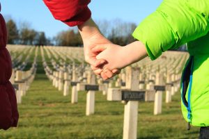 Genitore che tiene la mano di un bambino in un cimitero