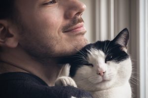 uomo che tiene un gatto bianco e nero